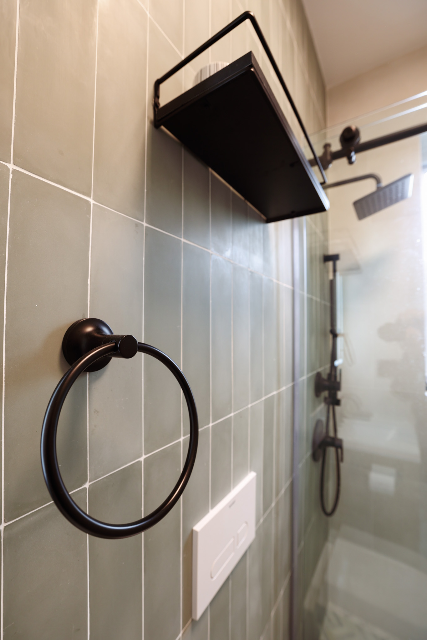 Bathroom shower — sage green vertical tile and matte black fixtures